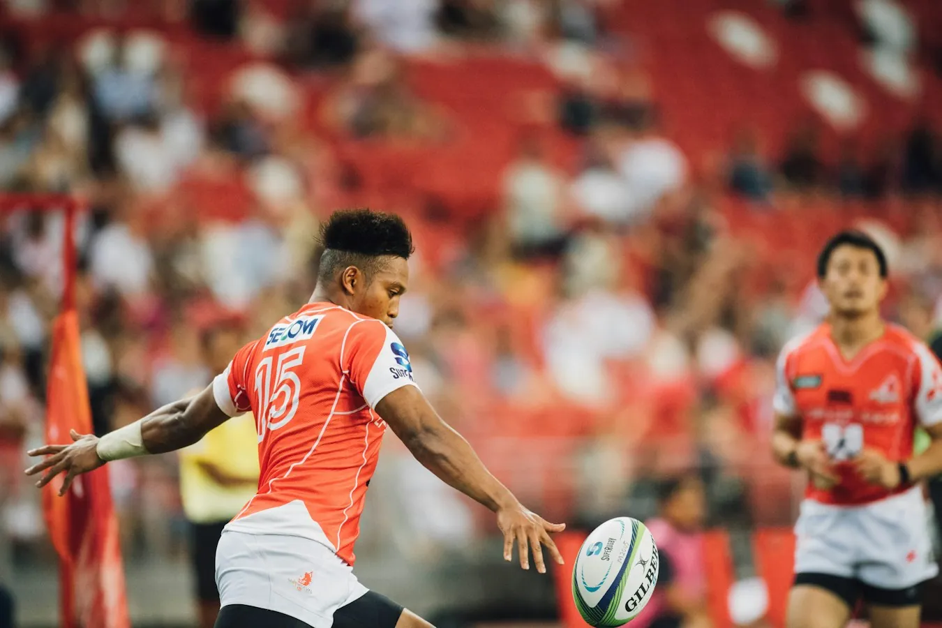 Rugby player preparing to kick the ball during a professional rugby match